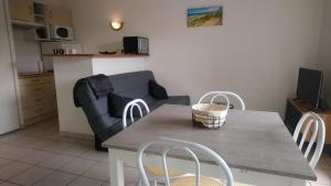 sala de estar con mesa, sillas y sofá en Soulac-Sur-Mer avec Piscine, en Soulac-sur-Mer