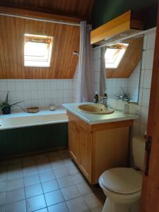 ein Badezimmer mit einem Waschbecken, einer Badewanne und einem WC in der Unterkunft Haras des Buissonnets in Bois-Anzeray
