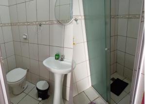 uma casa de banho com um lavatório, um chuveiro e um WC. em Pousada São Marcos em Santos