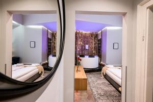 a mirror reflecting a room with two beds and a tub at Arts Apartments City Center in Krakow
