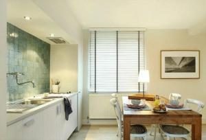 a kitchen with a table with chairs and a sink at midiSud Apartment in Ghent