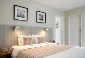 a bedroom with a large bed with two pictures on the wall at midiSud Apartment in Ghent