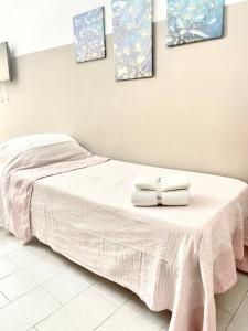 una camera da letto con un letto con due asciugamani sopra di Pigna Tommy House a Sanremo
