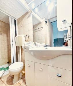 un bagno con un water, un lavandino e uno specchio di Pigna Tommy House a Sanremo Altre 16 foto