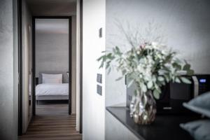 Marchegg Apartments في ناتورنو: مزهرية من الزهور على طاولة في غرفة