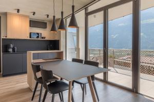 a kitchen and dining room with a table and chairs at Marchegg Apartments in Naturno
