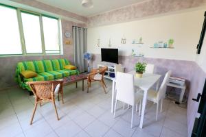 a living room with a couch and a table and chairs at Family apartment in Torre Pali with private 100 sqm garden in Torre Pali 
