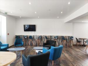 a waiting room with blue chairs and tables at La Côte de Lumière in La Tranche-sur-Mer