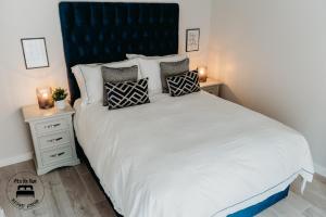 een slaapkamer met een groot wit bed met kussens bij Stylish Belfast City Centre 2 Bedroom Apt Free Parking in Belfast