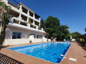 een zwembad voor een gebouw bij HomeSweetHome in Paphos City