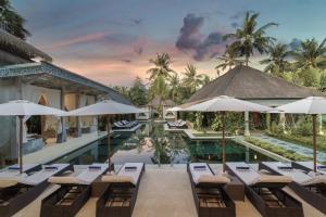 une image d'une piscine du complexe avec des chaises et des parasols dans l'établissement Rascals Hotel - Adults Only, à Kuta Lombok