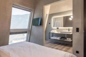 a bathroom with a bed and a mirror and a sink at Marchegg Apartments in Naturno