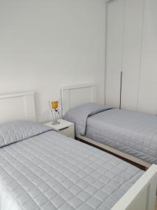 Atrium Residency في تيرانا: سريرين في غرفة بيضاء مع سريرين sidx sidx