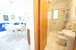 a bathroom with a sink and a toilet and a dining room at Family apartment in Torre Pali with private 100 sqm garden in Torre Pali  +24 photos