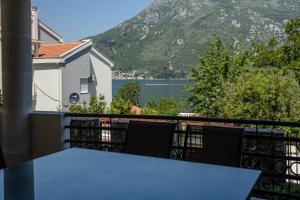 a table on a balcony with a view of a mountain at Ana Apartment in Kotor