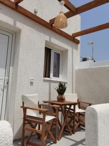 a patio with a table and chairs on a building at Villa Konstantinos in Perissa