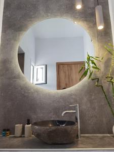 a bathroom with a stone sink and a mirror at Villa Konstantinos in Perissa