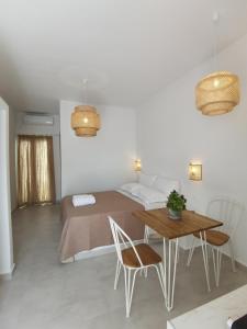 1 dormitorio con 1 cama, mesa y sillas en Villa Konstantinos, en Perissa