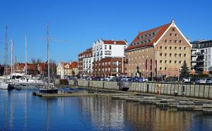 a marina in a city with boats and buildings at Szafarnia in Gdańsk