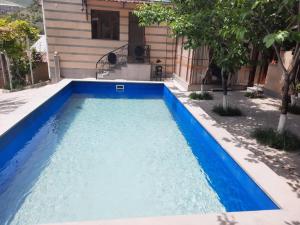 a pool with blue water in front of a house at Guest House LEADER in Ijevan