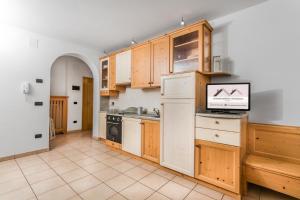 a large kitchen with wooden cabinets and appliances at Appartamenti Centrale in Andalo