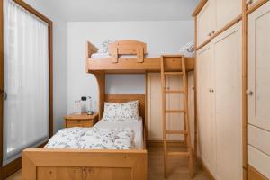 - une petite chambre avec des lits superposés et une échelle dans l'établissement Appartamenti Centrale, à Andalo