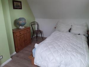 ブランケンブルクにあるFerienhaus Rosiのベッドルーム(白いベッド1台、木製ドレッサー付)