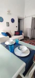una mesa con platos y cuencos en la sala de estar en Ideale per escursionisti, a pochi minuti dal mare e dalle falesie- Casa Celeste, en Cisano sul Neva