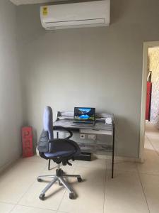 einen Stuhl vor einem Schreibtisch mit einem Laptop in der Unterkunft Newly Built 2 bedroom En-suite Apt. in Accra