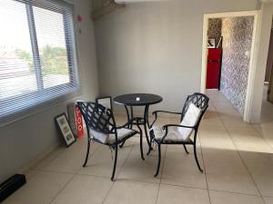 ein Esszimmer mit einem Tisch und 4 Stühlen in der Unterkunft Newly Built 2 bedroom En-suite Apt. in Accra
