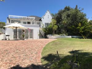 a house with a brick driveway and an umbrella at 4 Duke Street Flat#2 in Mossel Bay