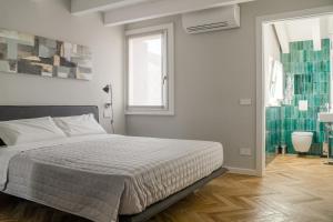 een witte slaapkamer met een bed en een raam bij HomeThirtyFour in Verona