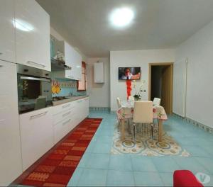 una cucina con tavolo e TV a parete di Graziosa casa vacanza vicino al mare a Sperlonga centro! a Sperlonga