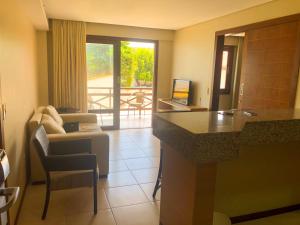 a living room with a couch and a table in a room at Kariri Beach - 207 - Praia do Cumbuco, Caucaia in Cumbuco