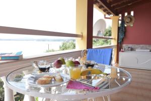 a glass table with food on it on a balcony at Baracunda Apartments in Barbati