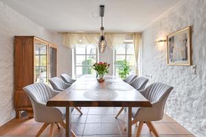 comedor con mesa de madera y sillas blancas en Haus Bella, en Schwangau