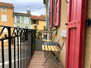 a balcony with two benches and a red door at Appartement 4 pers plein centre ville, wifi, balcon in Laragne