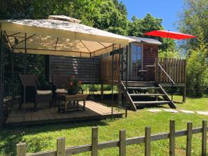 Payzac的住宿－The Dordogne Huts with Private Pool and Jacuzzi，小屋设有1个带遮阳伞的甲板