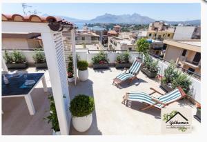 a patio with two chairs and a table on a balcony at Gelkamar Apartment in Santa Flavia