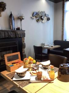 uma mesa de jantar com comida e uma lareira em AUBERGE DE LA VOUTE em Chooz