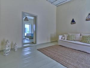a white living room with a couch and a rug at Flair Naousa in Naousa