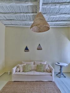 een woonkamer met een witte bank en een hanglamp bij Flair Naousa in Naousa