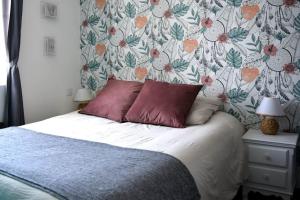 - une chambre avec un lit et un papier peint floral dans l'établissement Appartement Place du Marché, à Mers-les-Bains