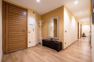 een hal met een houten deur en een spiegel bij Hauzify I Apartament Sant Roc in L'Ametlla de Mar