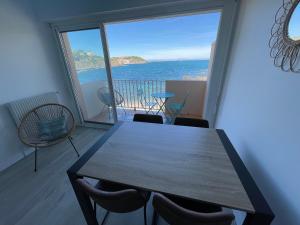 ein Esszimmer mit einem Tisch und Meerblick in der Unterkunft AZUR-Les pieds dans l'eau-Vue sur Mer et Clocher de Collioure en toile de fond - WIFI FIBRE- PARKING Couvert in Collioure