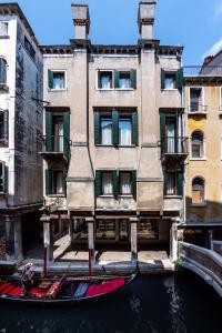 a gondola in a canal in front of a building at Al Gazzettino in Venice