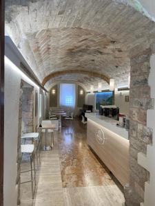 a kitchen and dining room with a stone wall at Camere Santa Chiara in Assisi