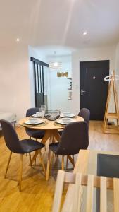 ein Esszimmer mit einem Holztisch und Stühlen in der Unterkunft Magnifique appartement rénové plein centre-ville in Marmande
