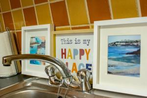 un lavello da cucina con due quadri incorniciati sul bancone di 125 - The Duplex at Gort Na Coiribe, by Shortstays a Galway Altre 17 foto