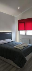 1 dormitorio con 1 cama grande y ventana roja en ALOJAMIENTOS AVICHE 6, en Santander